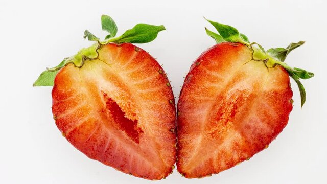 Time lapse of rotting crushed strawberries and the development of mold on a white background, 4K video