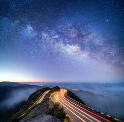 Astrophotography shot of hairpin turn with galactic core milky way rising on Madeira Island,...