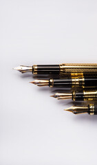 Fountain pen, four beautiful fountain pens in detail on white background, top view.