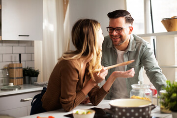 Happy smiling couple cooking together. Husband and wife preparing fresh pasta at home.