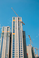 Fototapeta na wymiar Modern apartment building with crane on construction site