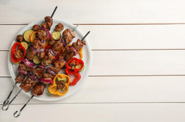 Metal skewers with delicious meat and vegetables served on white wooden table, top view. Space for text - Powered by Adobe