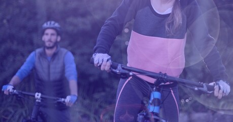 Obraz premium Composition of caucasian man and woman riding bicycles in forest