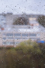 Rain drops on a window, background texture. Street, city behind glass