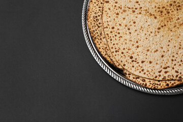 Tasty matzos on black background, top view with space for text. Passover (Pesach) celebration