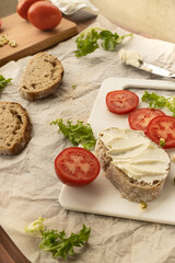 Sandwiches with cream cheese and tomatoes on the table