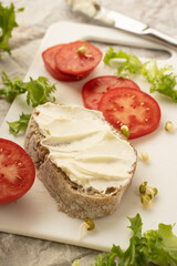 Fototapeta na wymiar Sandwiches with cream cheese and tomatoes on the white board