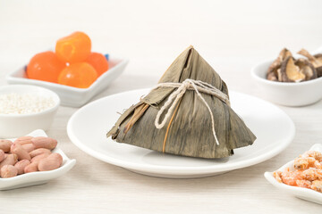 Zongzi. Rice dumpling for Dragon Boat Festival on bright wooden table background with ingredient.