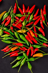 red and green chili peppers on dark background