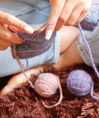 Young woman knitting scarf blue and beige colors, freelance concept   