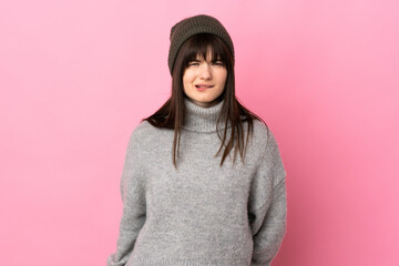 Teenager Ukrainian girl with winter hat isolated on white background having doubts and with confuse face expression