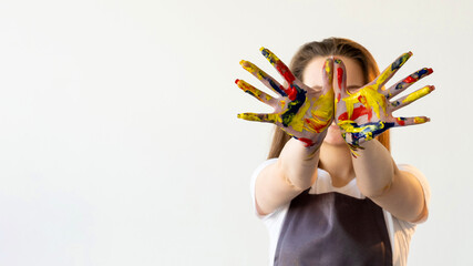 Painting school. Artistic inspiration. Creative hobby. Advertising background. Unrecognizable woman showing hands palm with colorful paint splashes isolated white copy space.