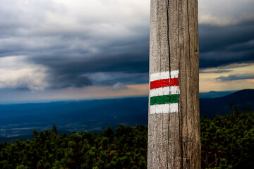 red and green mark of trail in the mountain on background cloudy sky