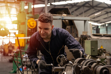 Obraz na płótnie Canvas Male engineer worker maintenance machine in industry factory. Male technician worker working, repair machine lathe metal in the industry factory