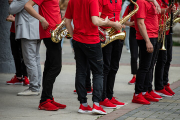 orchestra in red t-shirts and sneakers playing the saxophone