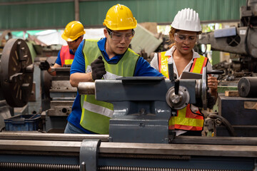 Group of male and female worker maintenance machine in industry factory. Technician worker working, repair machine lathe metal in the industry factory