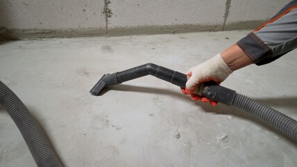 Cleaning the concrete floor surface with a vacuum cleaner. Remove dirt in the workplace, in the...