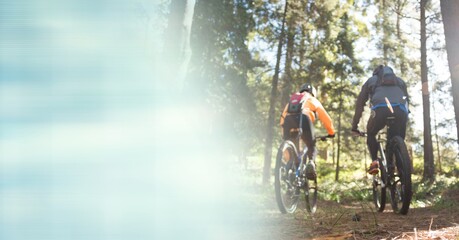 Obraz premium Composition of people riding bicycle in forest with blur