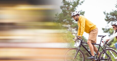 Obraz premium Composition of people riding bicycle in forest with motion blur