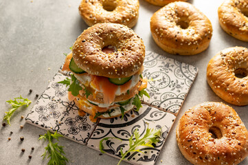 Fresh healthy sandwiches with seeded bagel, mayo, salmon, egg, cucumber and rocket