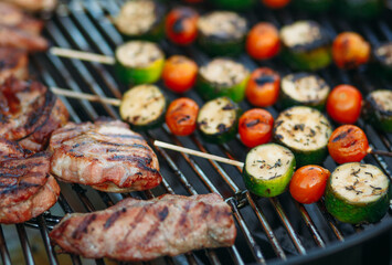 Grilling on summer weekends. Fresh meat and vegetables are grilled. Close-up.