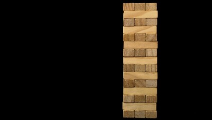 Jenga game. A column made of wooden elements on a black background