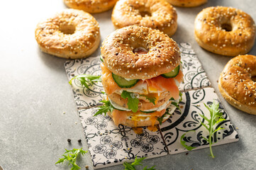 Fresh healthy sandwiches with seeded bagel, mayo, salmon, egg, cucumber and rocket