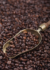 Fototapeta premium Fresh roasted coffee beans in vintage steel scoop on beans background.