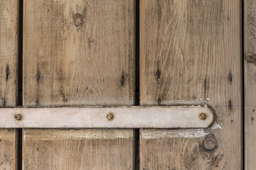 Part of a very old wooden door with a white lacquered bracket