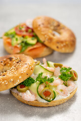Fresh healthy sandwiches with seeded bagel, sea food and salad