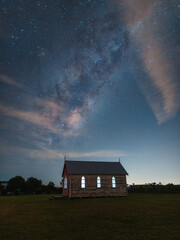 Rising milky way galaxy over little chapel on the countryside.