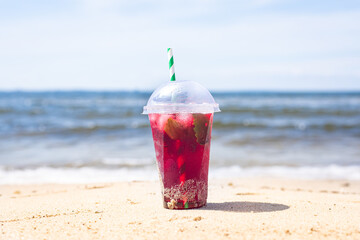 ice drink red lemonade soda on the beach cherry or strawberry fresh juice, sea coast shore, summer surf wave background refreshing relax positive mood vacation top view