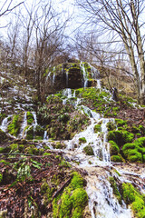 Fototapeta na wymiar Amazing waterfall stream in forest, early spring. Nature landscape. Waterfall Siga. Homolje mountains, Serbia
