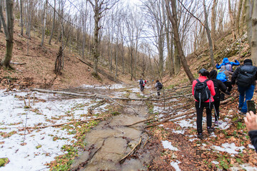 Group of hikers walking on the hike trail on snow winter day.