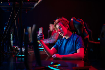 A young esports player records a video on his phone for his vlog from the training base of his team of gamers