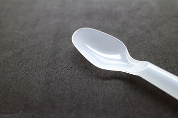 黒い背景の白いプラスチックスプーン