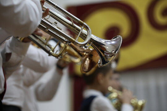 Musical instrument silver trumpet on the background of young musicians in the school orchestra performing at a concert.Close-up image.The concept of children's creativity and education
