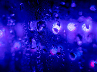 紫のライトに照らされる水滴