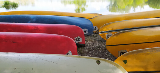 Plastic canoes in row without paddles as a summer camp concept