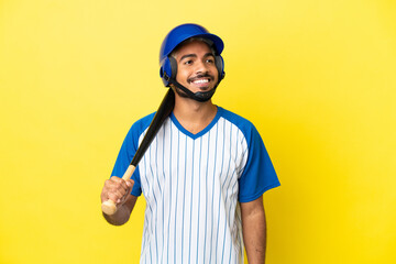 Young Colombian latin man playing baseball isolated on yellow background thinking an idea while looking up