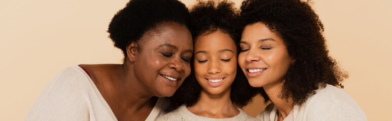 african american daughter, granddaughter and grandmother hugging cheeks to cheeks on beige background, banner