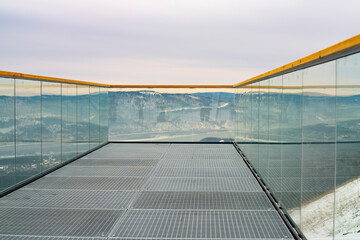 Observation deck with transparent glass railing and wooden railings.