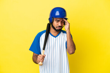 Young Colombian latin man playing baseball isolated on yellow background with headache