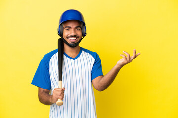 Young Colombian latin man playing baseball isolated on yellow background extending hands to the side for inviting to come