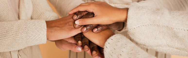 close up shot of african american middle aged, adult and preteen female hands holding together on beige background, banner
