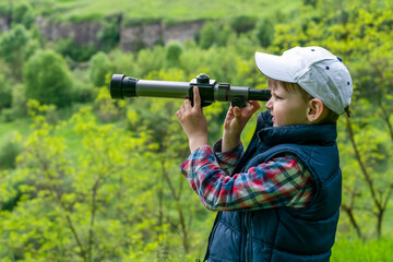 Child is looking through a spyglass.