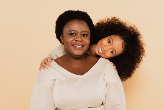 Joyful African American Granddaughter With Grandmother Isolated On Beige