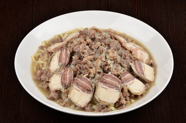 chopped pieces of bacon in soup with noodles, meat and onions