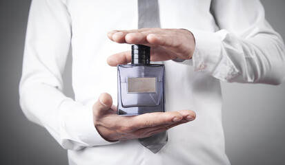 Man holding a bottle of perfume.