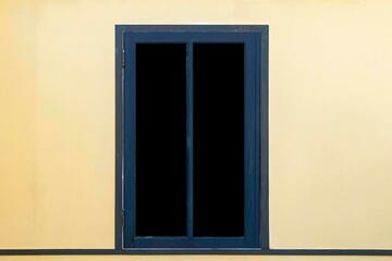 Dark blue antique wooden window frame and light yellow cement wall